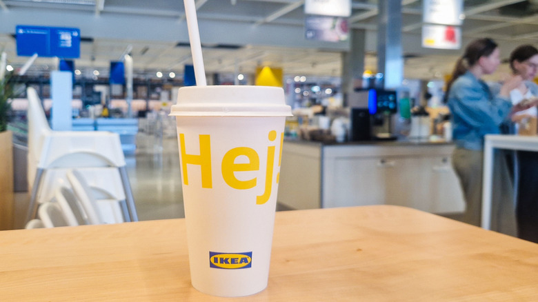 A close up of an IKEA drinks cup with a blurred cafeteria in the background