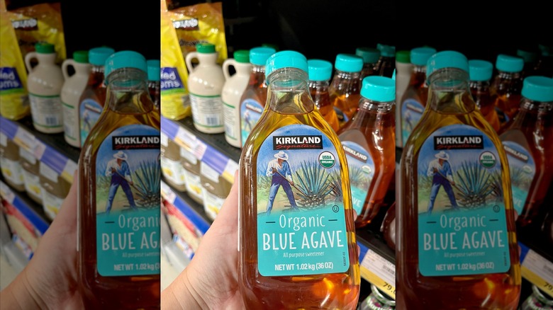Hand bolding bottle of organic agave syrup at Costco