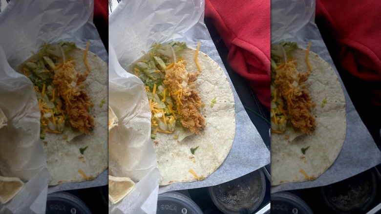 Popeyes chicken wrap on white paper in car