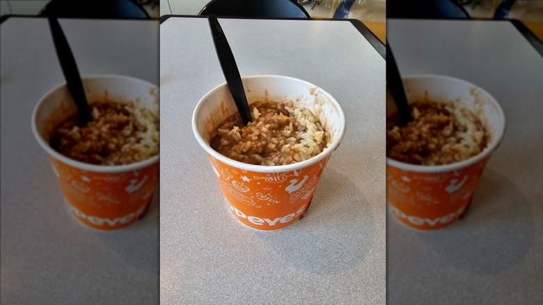 Popeyes red beans and rice in paper bowl on grey table