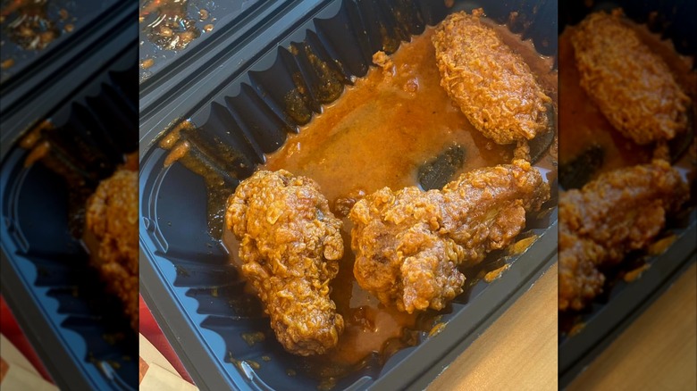 Popeyes signature hot wings in black plastic to-go container