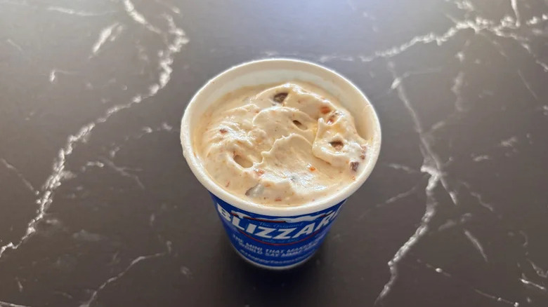 Butterfinger Blizzard in a paper cup top view on a black marble counter