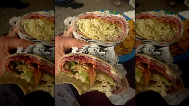 Hand holding Jimmy John's Tuscan Italian wrap