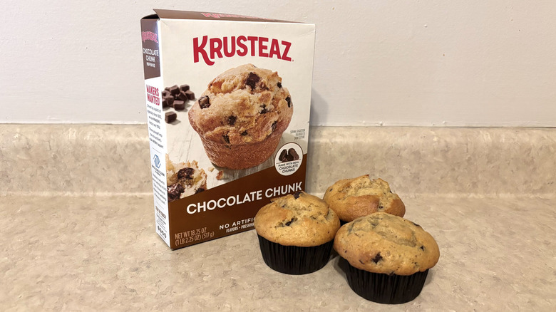 Krusteaz chocolate chunk muffin mix box with muffins on neutral counter