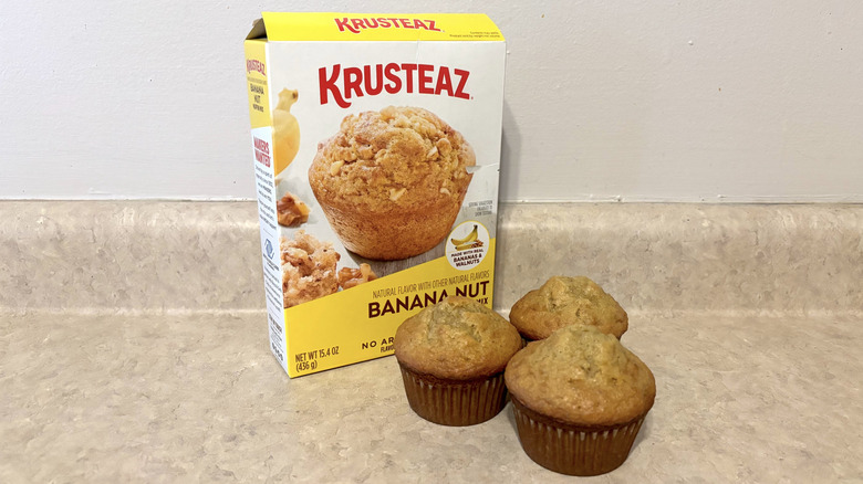 Krusteaz banana nut muffin mix box with muffins on neutral counter