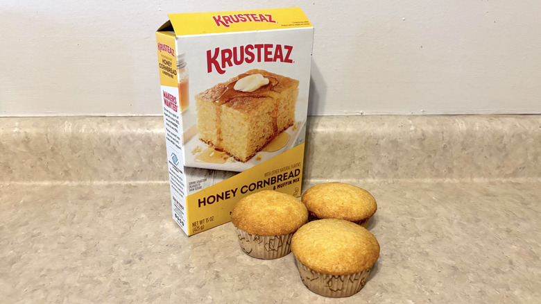 Krusteaz honey cornbread muffin mix box with muffins on neutral counter