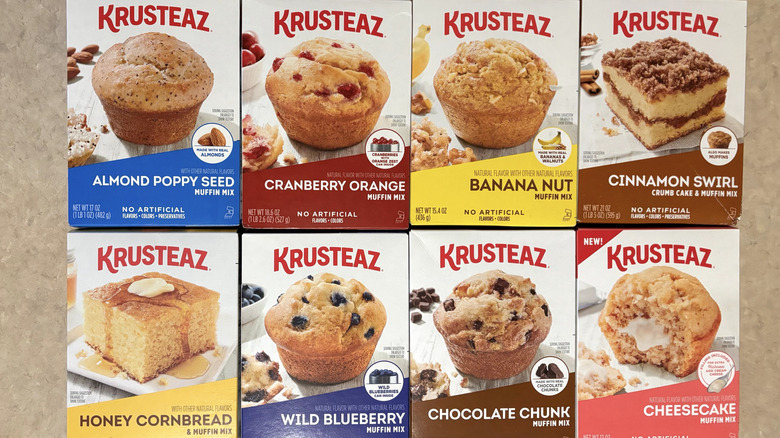A variety of Krusteaz muffin mixes in boxes on neutral counter