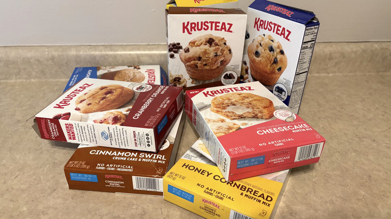 A variety of Krusteaz muffin mixes in boxes on neutral counter