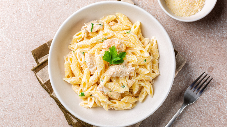 Chicken alfredo in white bowl with silver fork