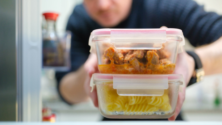 Person pulling leftovers out of the refrigerator