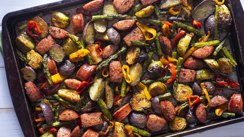 Roasted vegetables with sausage on baking sheet