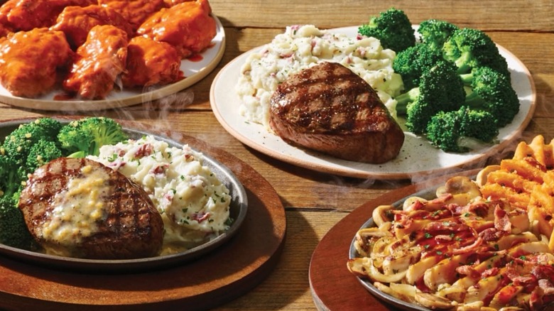 Assortment of dishes with mashed potatoes, broccoli, steaks, and boneless wings