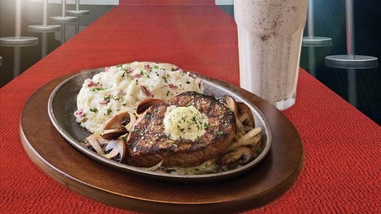 Steak and mashed potatoes on platter on red carpet