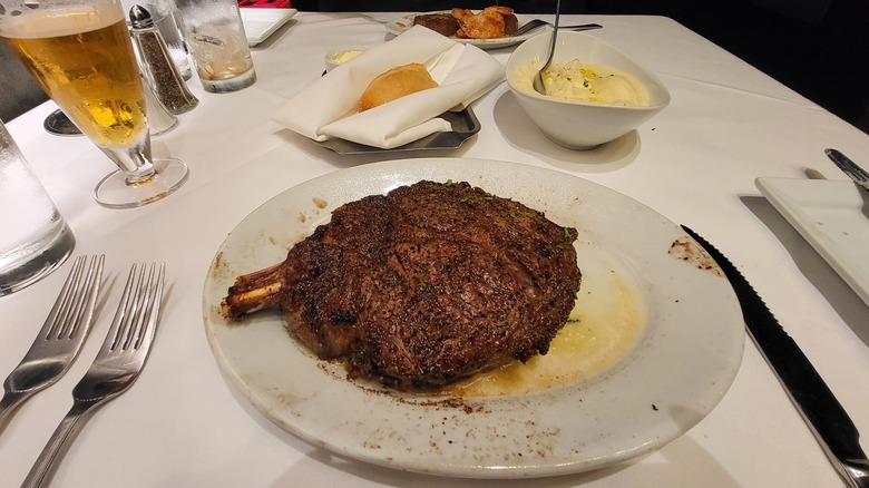 Plated Cowboy Ribeye, mashed potatoes, and beer at Ruth's Chris Steak House