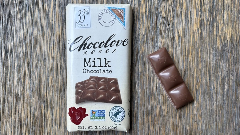 Wrapped Chocolove milk chocolate bar on table with long rectangular piece adjacent, consisting of three sections adorned with hearts
