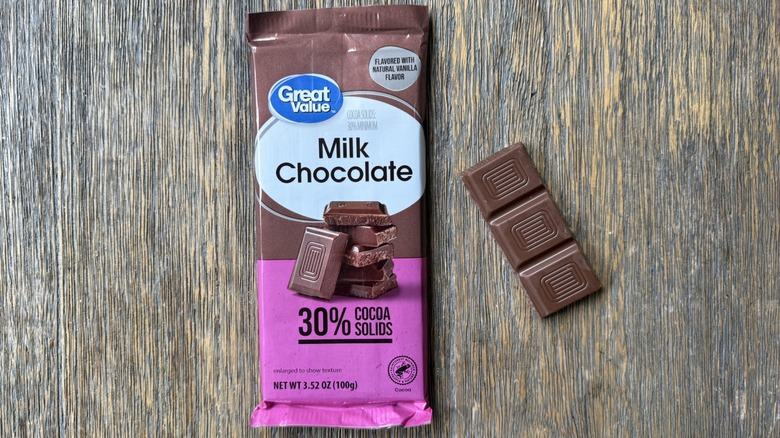 Wrapped Great Value milk chocolate bar on table with long rectangular piece adjacent, consisting of three sections