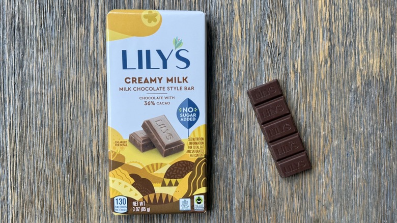 Wrapped Lily's milk chocolate style bar on table with rectangular piece adjacent, consisting of five sections