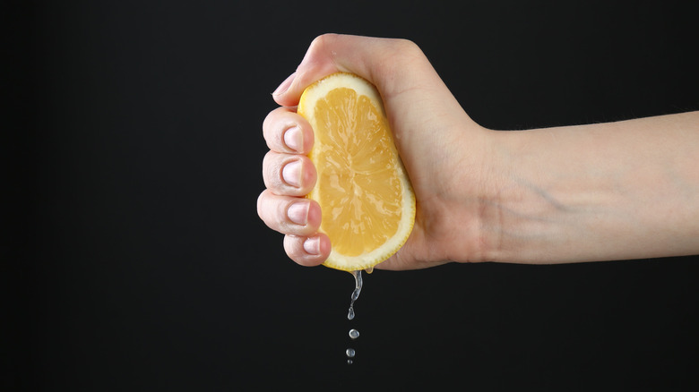Person squeezing the juice from half a lemon