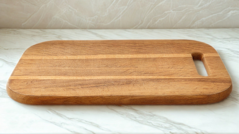 Wooden cutting board on marble countertop