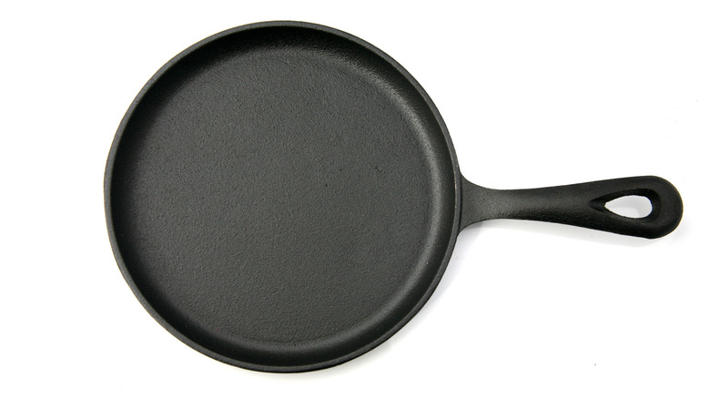 Black cast iron pan on white background
