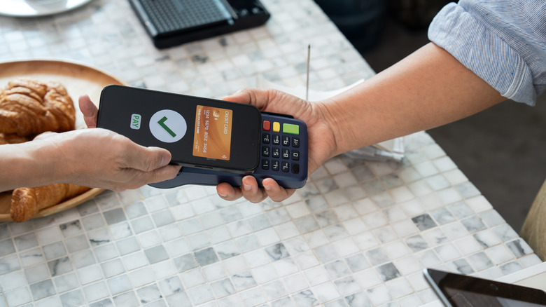 Paying with contactless credit card over marble countertop