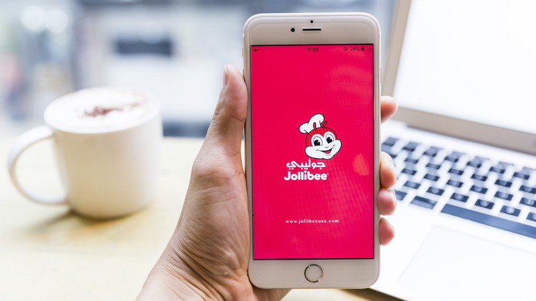Hand holding phone with Jollibee app
