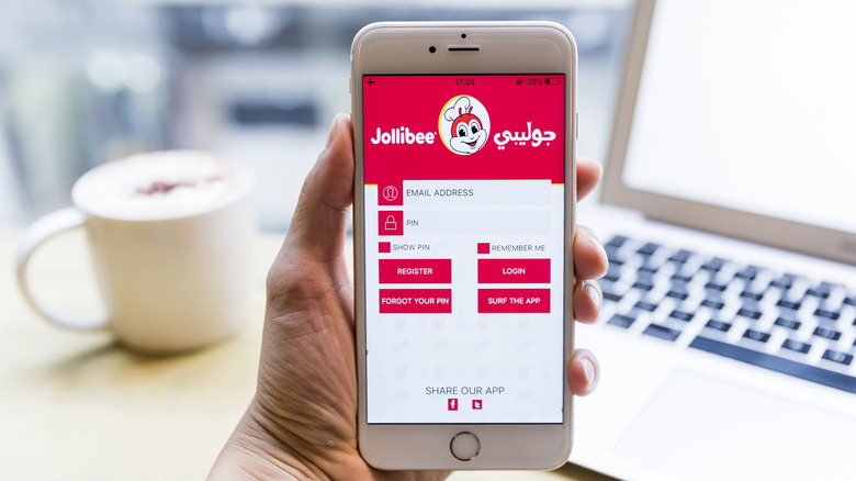 Hand holding phone with Jollibee app