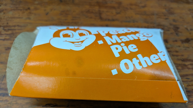 Three peach mango pies on wooden plate