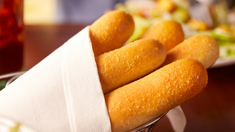 Olive Garden breadsticks in basket with white napkin