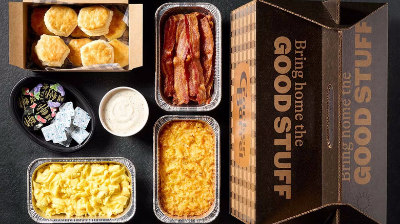 A breakfast family meal for takeout at Cracker Barrel including a box of biscuits and foil tubs of mac and cheese and bacon strips