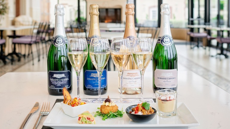 Bottles of Domaine Carneros wine with small bites