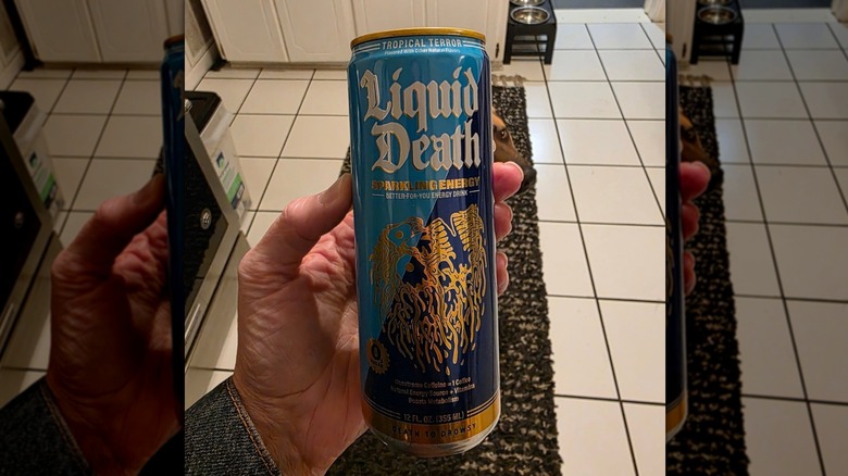 Hand holding can of Liquid Death Sparkling Energy in kitchen