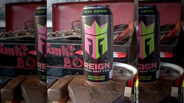 Can of Reign Watermelon Sour Gummy Energy on machinery