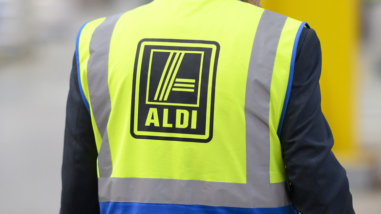 Back of person wearing bright yellow Aldi vest