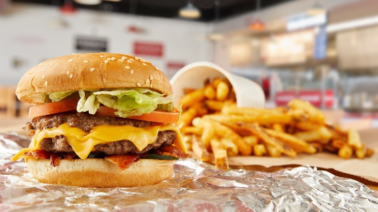 Double cheeseburger and fries over aluminum foil at Five Guys