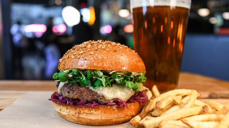 Elk burger, fries, and beer glass at Hopdoddy Burger Bar