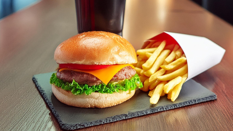 Hamburger, fries, and soft drink on restaurant table