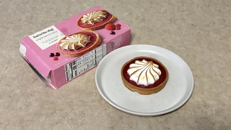 A Favorite Day berry tart on a white plate next to a pink box