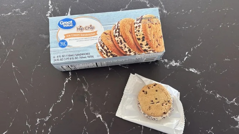 A Hip Chip ice cream sandwich on wax paper next to its box on a black marble table