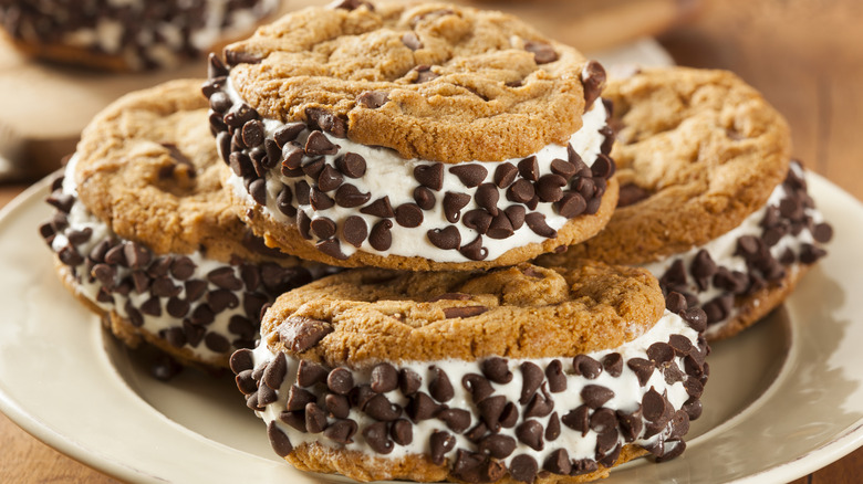 Ice cream sandwiches made with vanilla ice cream and chocolate chip cookies on a white plate