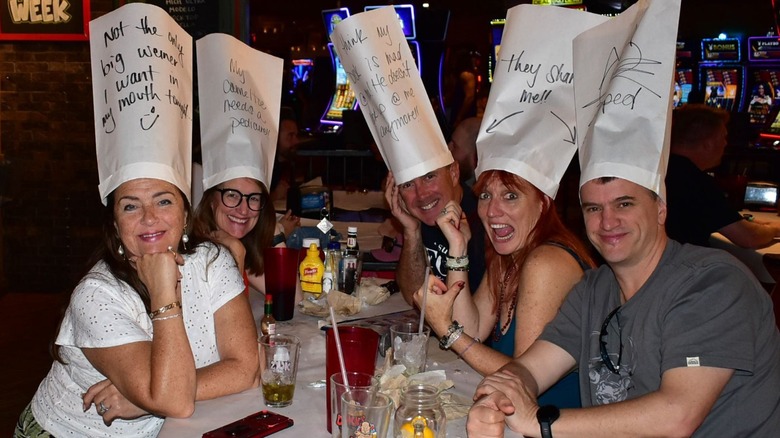 People wearing strange hats at a table
