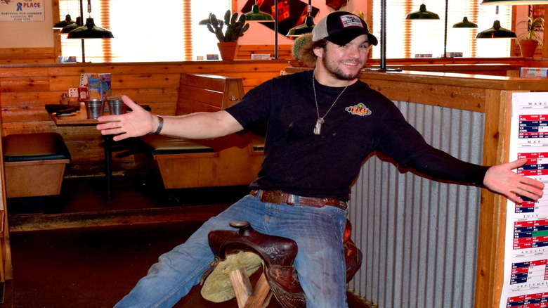 A man riding a horse saddle in Texas Roadhouse