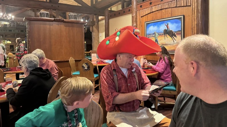 A man wearing a large strange red hat