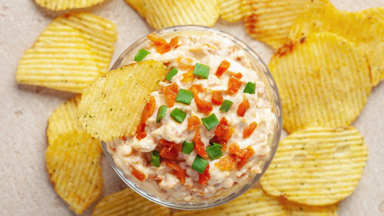 a bowl of dip surrounded by chips