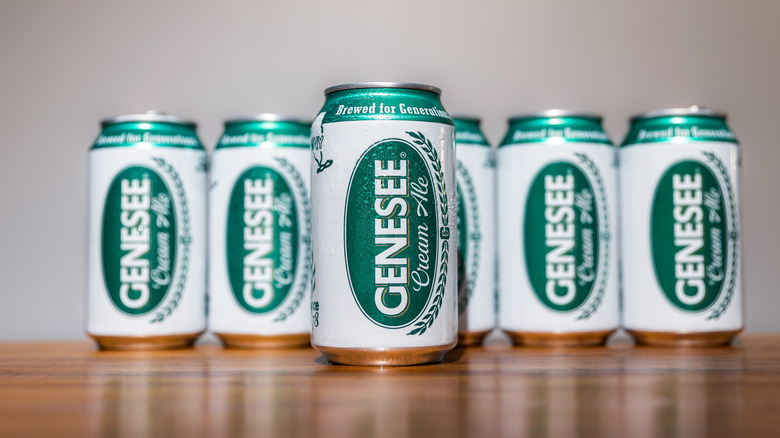 Cans of Genesee Brewery Cream Ale on a wooden bar top.