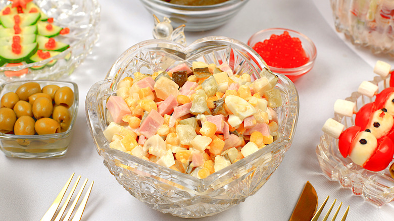 salad olivier in crystal bowl with potatoes and ham