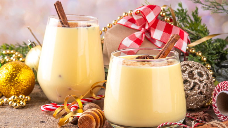 two glasses of eggnog on a holiday decorated table