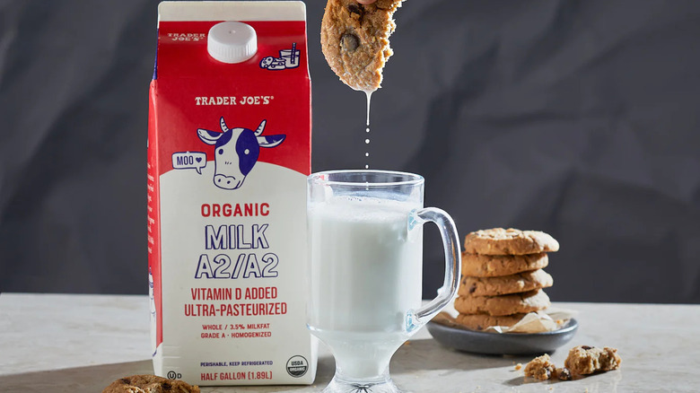A carton and glass of milk from Trader Joe's with cookies beside