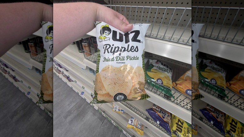 Hand holding bag of Utz chips at a Dollar Tree