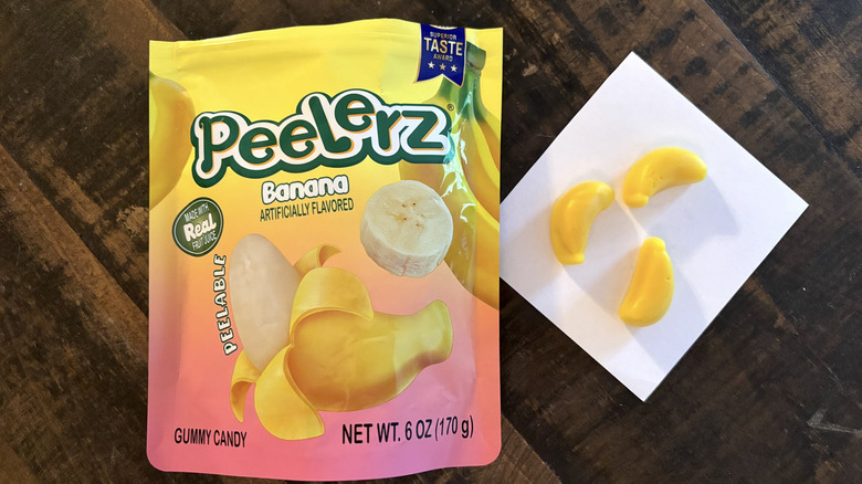 Peelerz banana flavored gummy candy in bag and paper on wooden table.